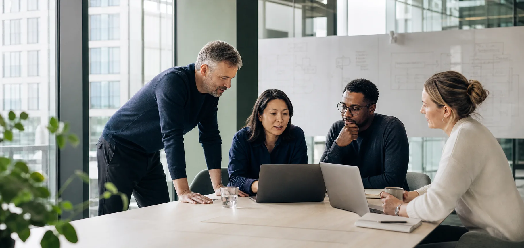 Vier IT-professionals werken samen rond een tafel